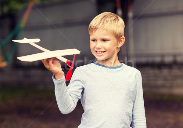 Stock fotó: Mosolyog · kicsi · fiú · tart · fából · készült · repülőgép