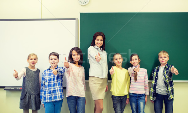 group of school kids and teacher showing thumbs up Stock photo © dolgachov