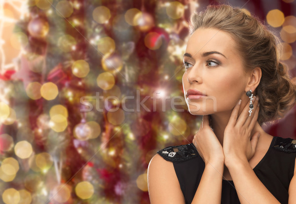 beautiful woman wearing earrings over lights Stock photo © dolgachov