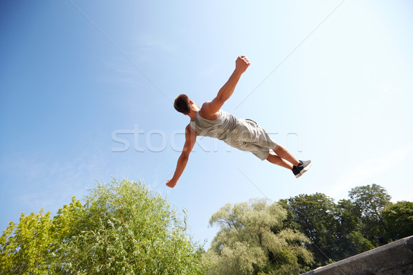 sporty young man jumping in summer park Stock photo © dolgachov