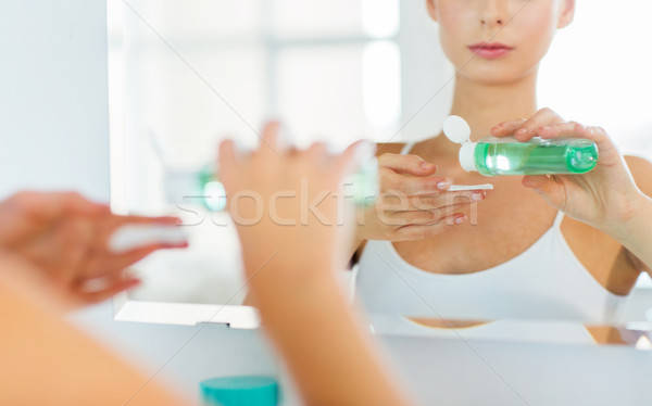 young woman with lotion washing face at bathroom Stock photo © dolgachov