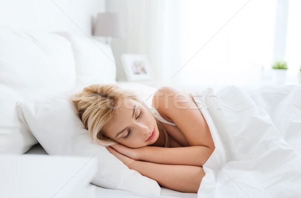 Genç kadın uyku yatak ev yatak odası konfor Stok fotoğraf © dolgachov