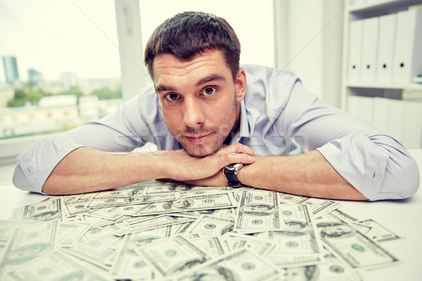 happy businessman with heap of money in office Stock photo © dolgachov