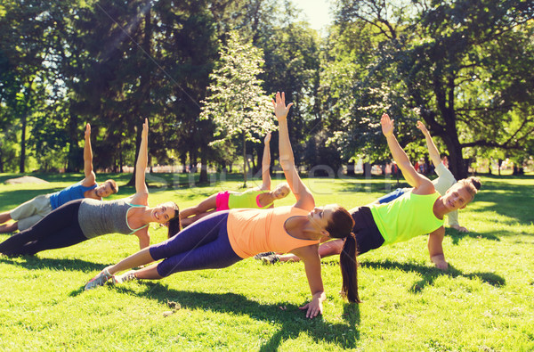 group of happy friends exercising outdoors Stock photo © dolgachov