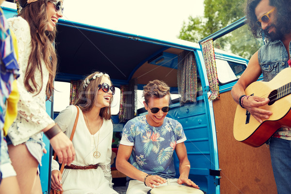 happy hippie friends playing music over minivan Stock photo © dolgachov