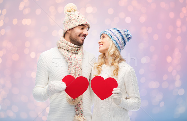 smiling couple in winter clothes with red hearts Stock photo © dolgachov