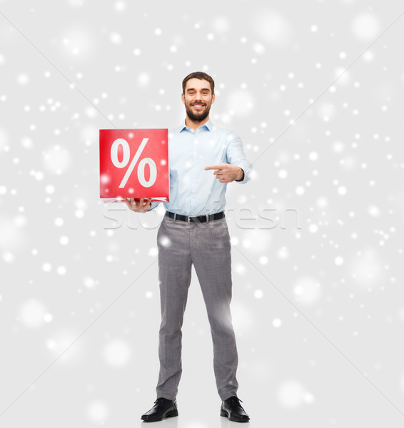 smiling man with red percentage sign over snow Stock photo © dolgachov