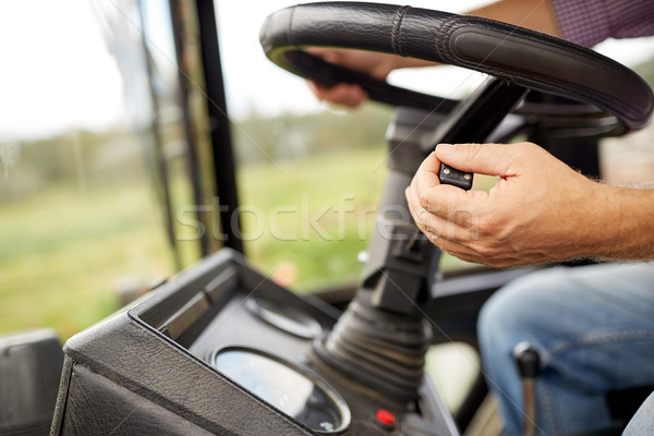 senior man driving tractor at farm Stock photo © dolgachov