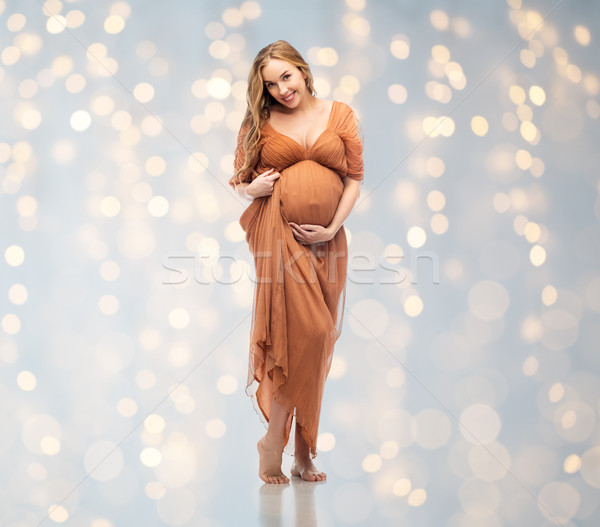 happy pregnant woman touching her big belly Stock photo © dolgachov