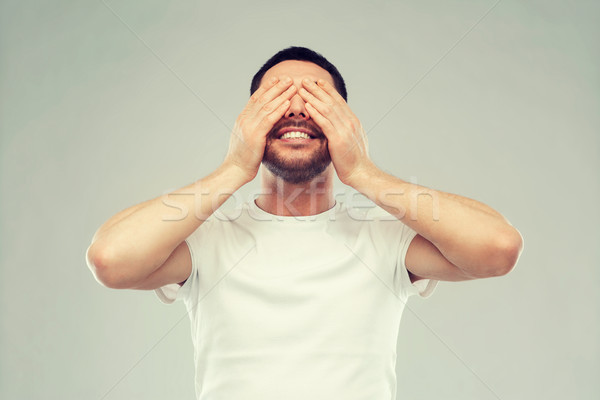 smiling man closing his eyes over gray background Stock photo © dolgachov