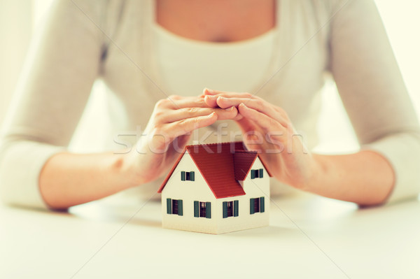 close up of hands protecting house or home model Stock photo © dolgachov