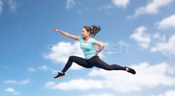 happy sporty young woman jumping in fighting pose Stock photo © dolgachov