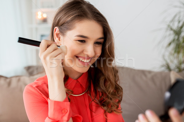 woman with eye shadow brush and mirror does makeup Stock photo © dolgachov