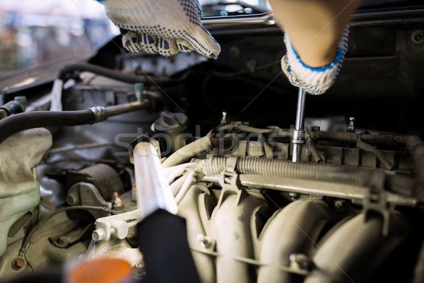 mechanic man with wrench repairing car at workshop Stock photo © dolgachov