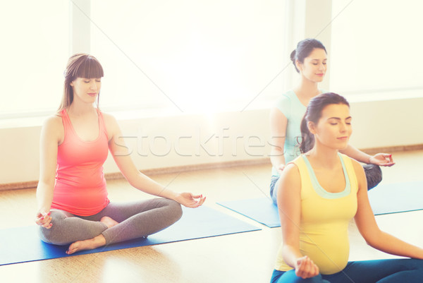 happy pregnant women exercising yoga in gym Stock photo © dolgachov