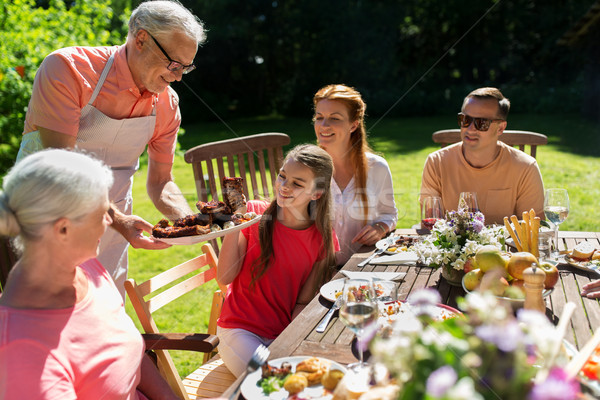 happy family having dinner or summer garden party Stock photo © dolgachov