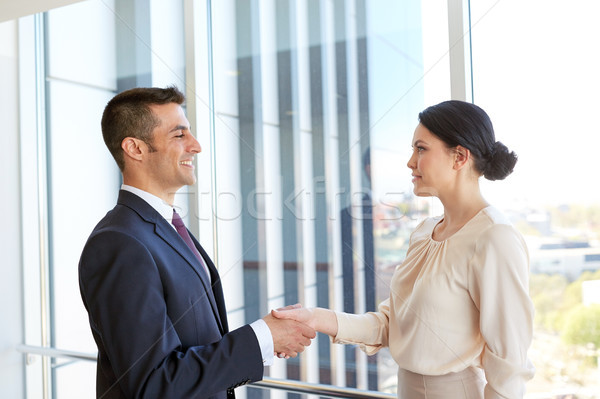 smiling business people shaking hands at office Stock photo © dolgachov