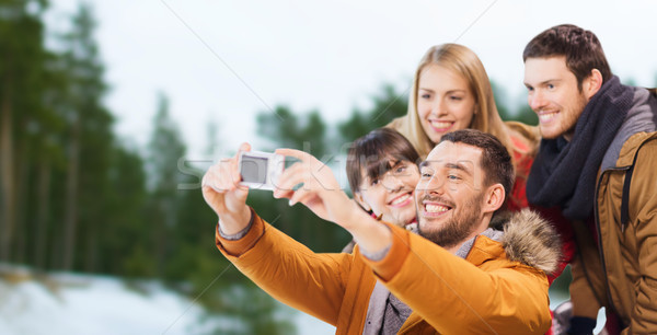 Stock photo: happy friends with camera on skating rink