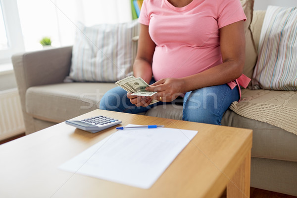 pregnant woman counting money at home Stock photo © dolgachov