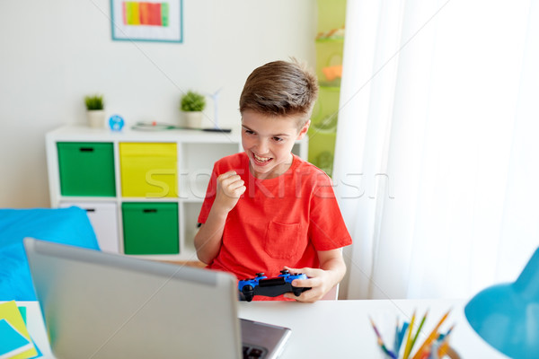 男孩 手柄 播放 視頻遊戲 筆記本電腦 商業照片 © dolgachov