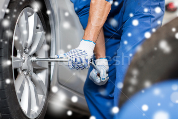 Stock photo: auto mechanic with screwdriver changing car tire