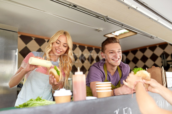happy sellers serving customers at food truck Stock photo © dolgachov