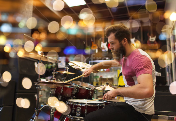 male musician playing cymbals at music store Stock photo © dolgachov