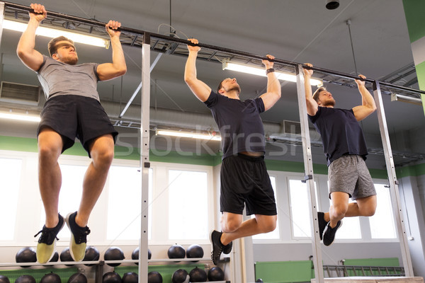 group of young men doing pull-ups in gym Stock photo © dolgachov