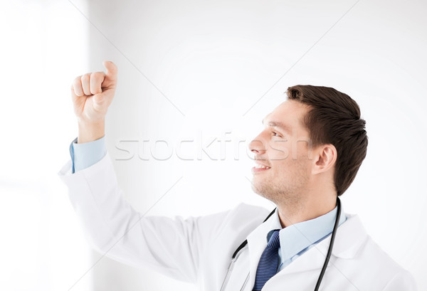 young doctor holding something imaginary Stock photo © dolgachov