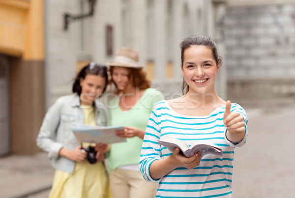 smiling teenage girls with city guide and camera Stock photo © dolgachov