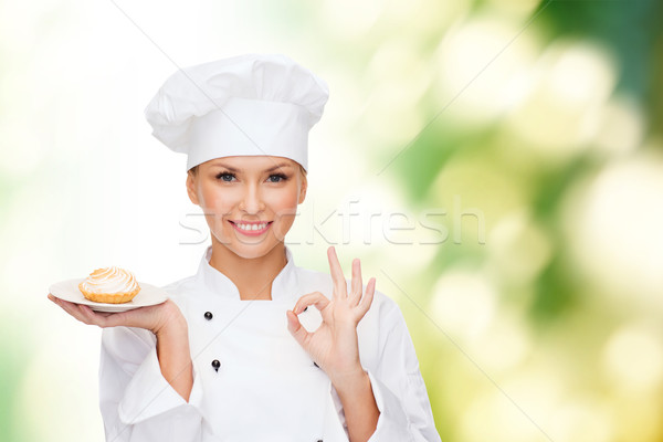 smiling female chef with cake on plate Stock photo © dolgachov