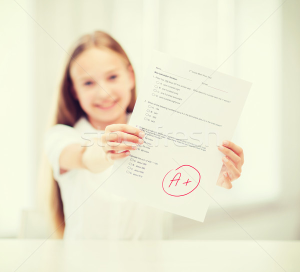 smiling little student girl with test and A grade Stock photo © dolgachov