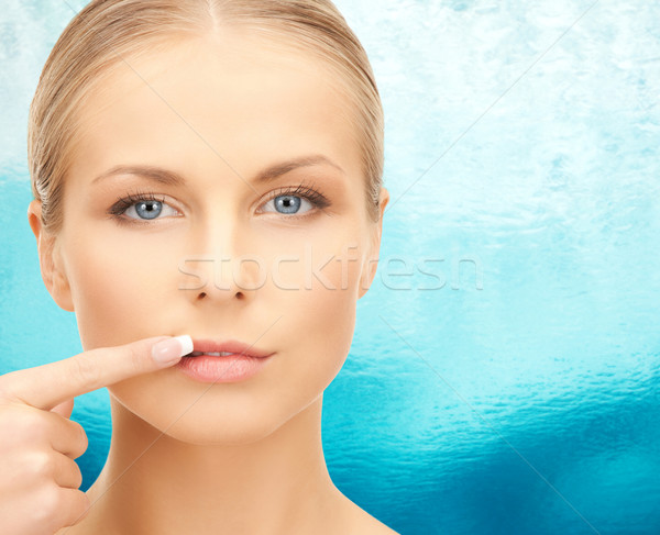 beautiful young woman pointing finger to her lips Stock photo © dolgachov