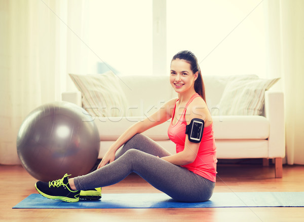 Stock photo: smiling girl with armband execising at home