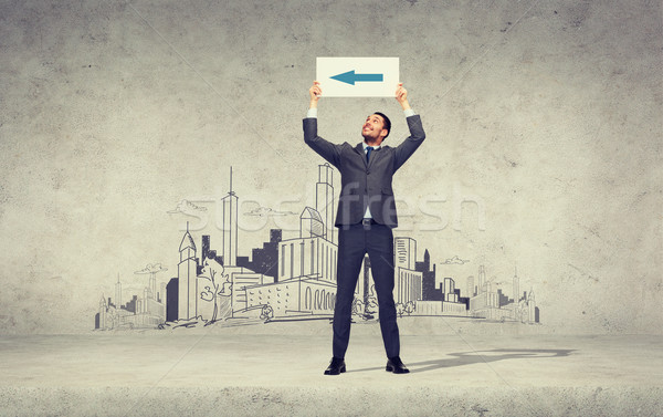 smiling businessman with arrow on white board Stock photo © dolgachov