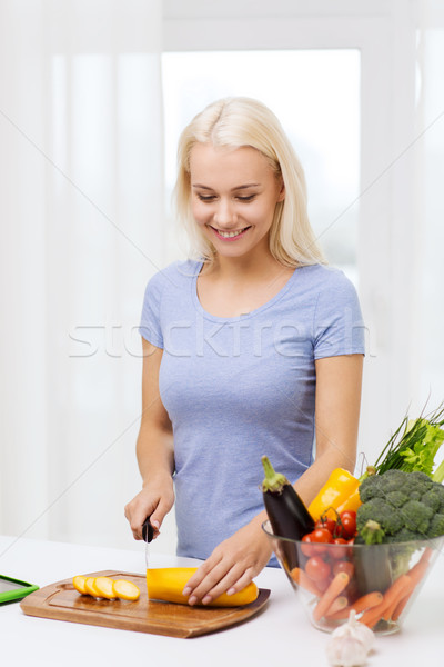 smiling young woman chopping vegetables at home Stock photo © dolgachov