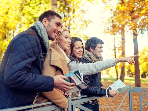 group of friends with map outdoors Stock photo © dolgachov