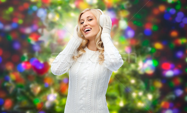 Stock photo: smiling young woman in winter earmuffs and sweater