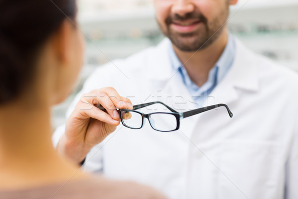 close up of optician with glasses at optics store Stock photo © dolgachov