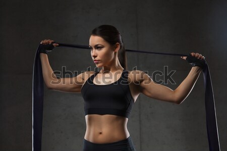 young woman flexing muscles in gym Stock photo © dolgachov