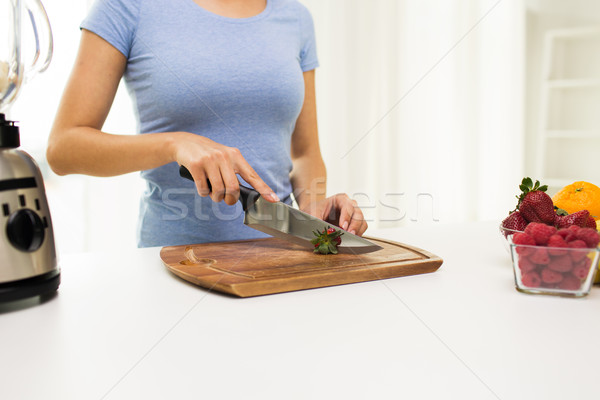 close up of woman chopping strawberry at home Stock photo © dolgachov