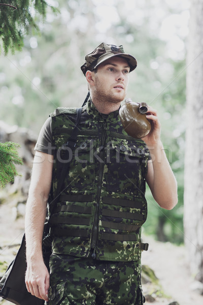 young soldier with gun and flask in forest Stock photo © dolgachov