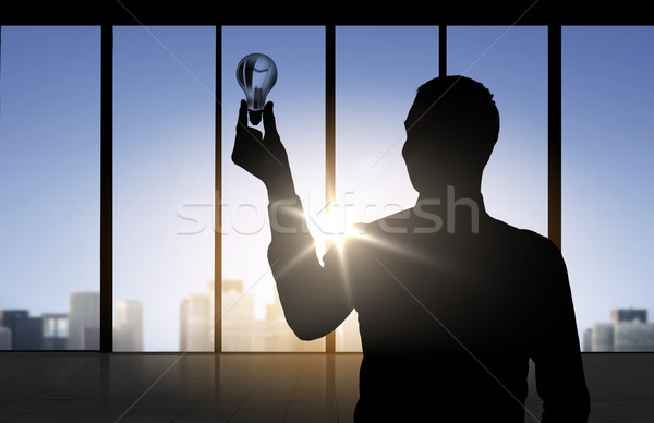 silhouette of businessman holding light bulb Stock photo © dolgachov