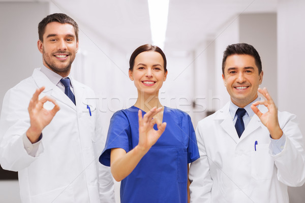 group of medics at hospital showing ok hand sign Stock photo © dolgachov