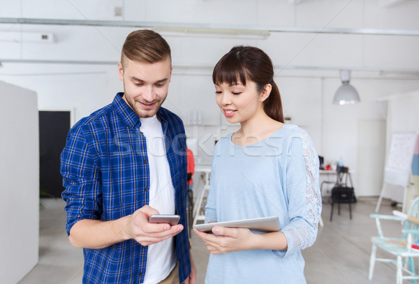 couple with smartphone and tablet pc at office Stock photo © dolgachov