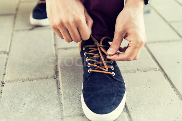 close up of male hands tying shoe laces on street Stock photo © dolgachov