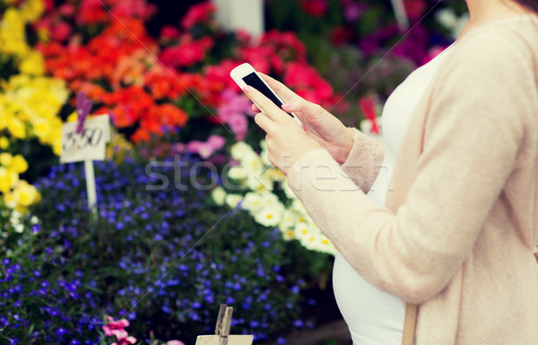 pregnant woman with smartphone at flower market Stock photo © dolgachov