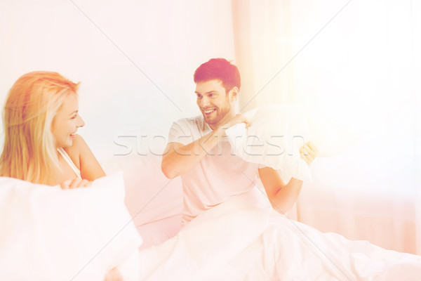 Foto stock: Feliz · casal · luta · de · almofadas · cama · casa · pessoas