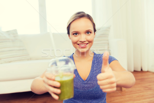 happy woman with cup of smoothie showing thumbs up Stock photo © dolgachov