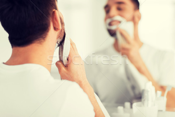 close up of man removing shaving foam from face Stock photo © dolgachov